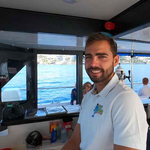 Captain Declan at the helm of the Magic Dolphin Eco catamaran.